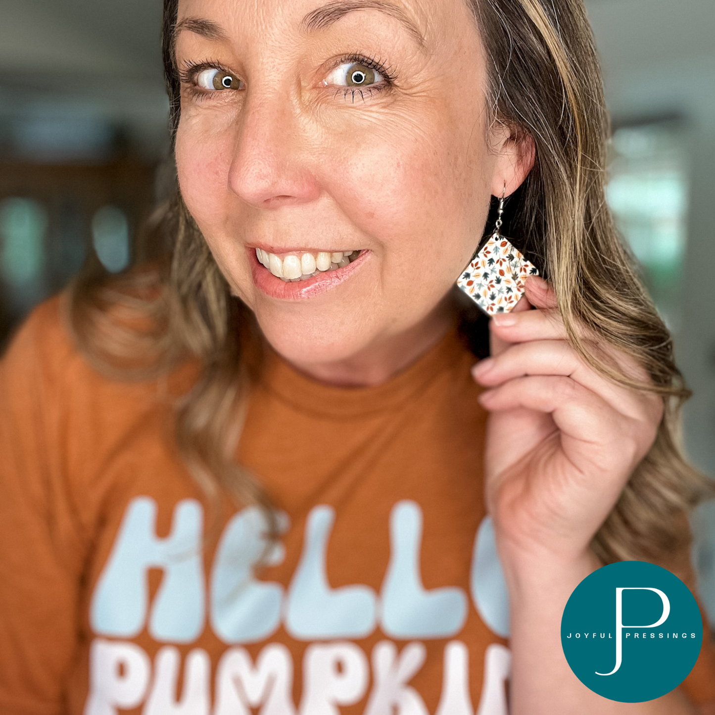 Fall leaves earrings displayed on model.