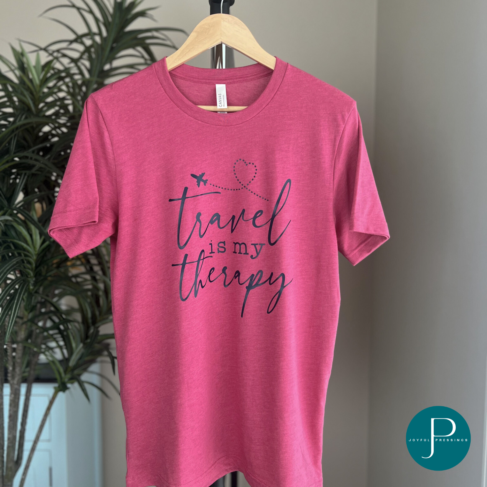 t-shirt display of travel is my therapy print on a raspberry colored tee