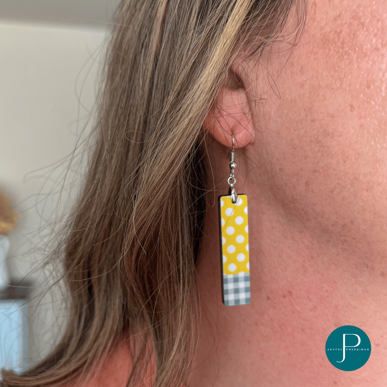 model showcasing yellow and white polka dot earrings with grey plaid.