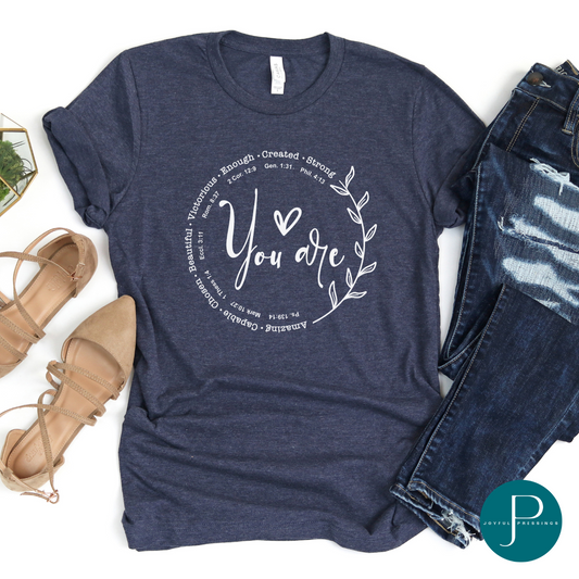 Flatlay of You are white graphic on a heather navy tee.